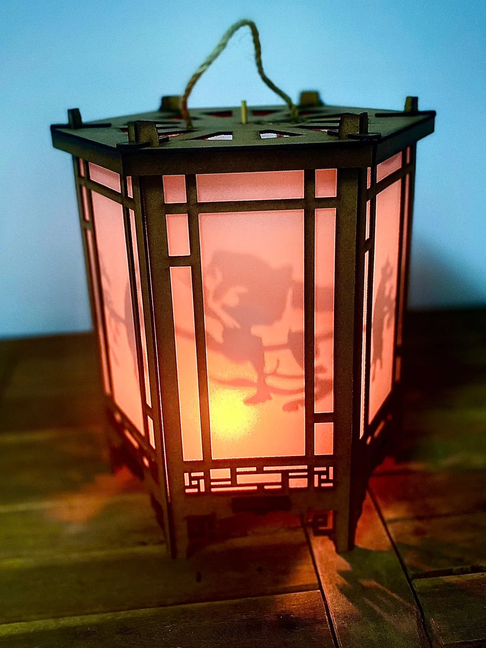 Đèn kéo quân thắp nến trên nền gỗ, ánh sáng ấm lan ra mặt bàn