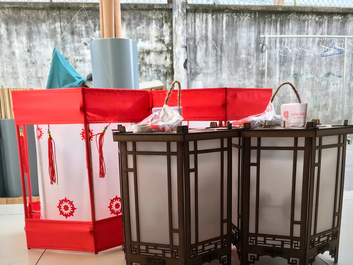 Đèn kéo quân xếp cạnh hộp quà giấy đỏ trước khi giao cho khách