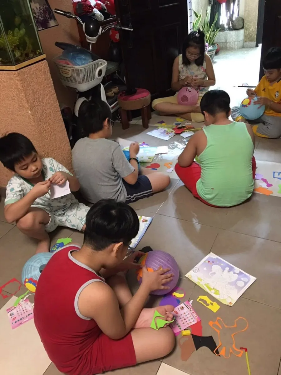 Đèn lồng Trung Thu — Bé đội mũ bảo hiểm, tay cầm đèn con bướm phát sáng dạo phố mua đèn.