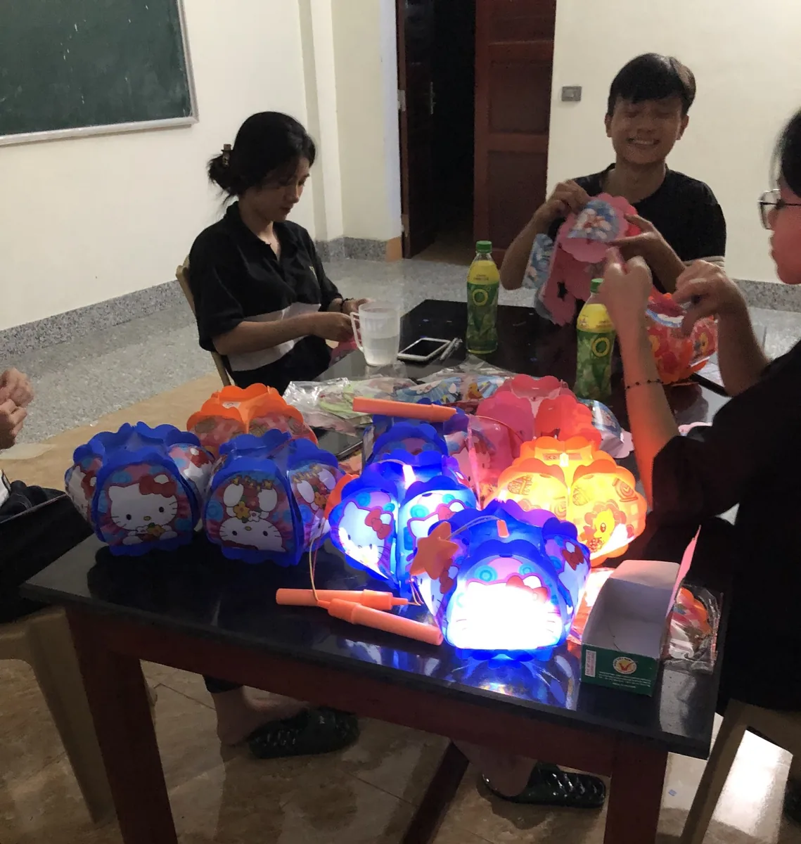 Đèn lồng Trung Thu — Lắp pin, thử đèn Hello Kitty trước khi giao cho khách — chiếc nào cũng phải sáng đều.